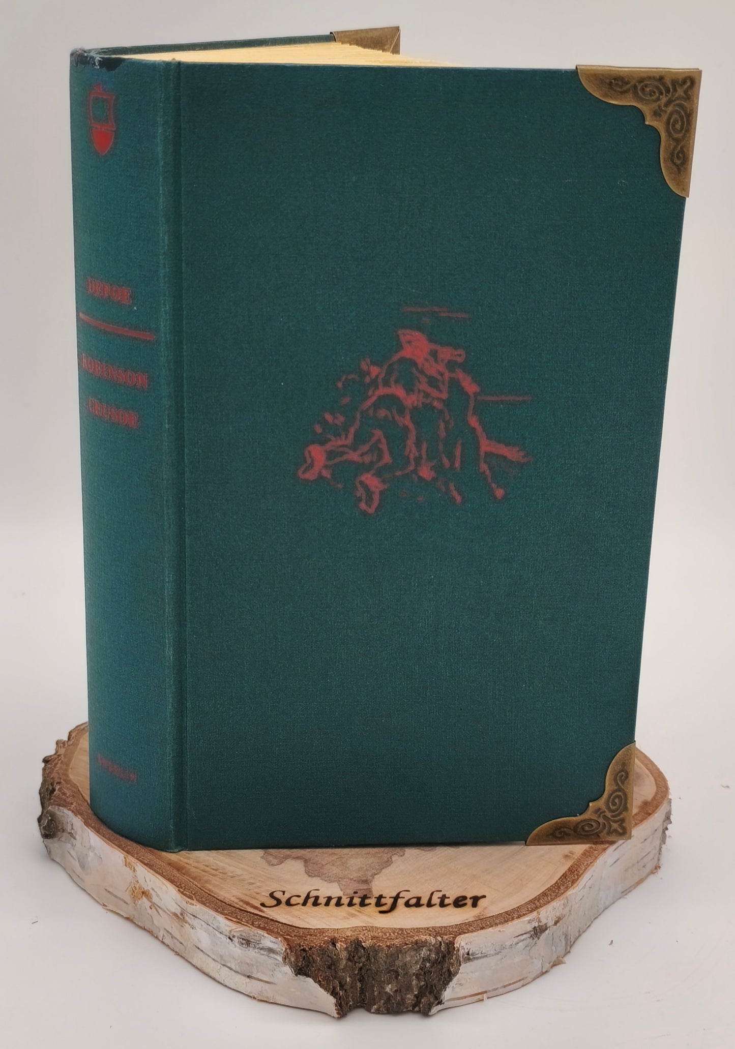 Gefaltetes Buch Kleeblatt, Rückenansicht mit grünem Einband auf Birkenscheibe