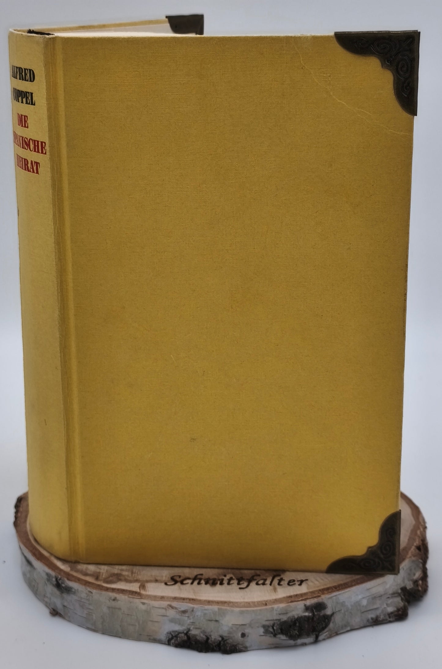 Gefaltetes Buch Gebrochenes Herz, Rückenansicht mit goldenem Einband auf Birkenscheibe