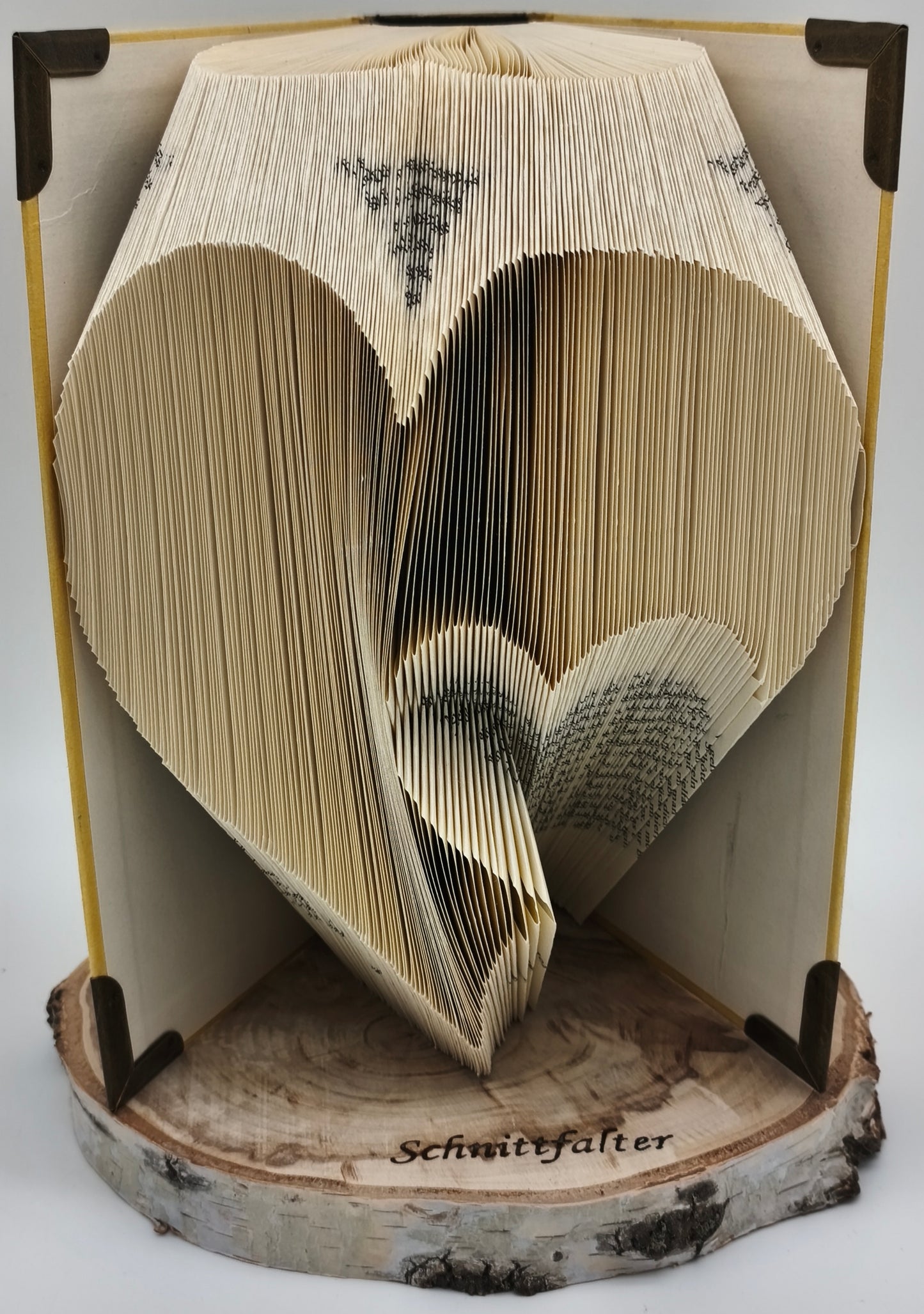 Gefaltetes Buch mit gebrochenem Herz-Motiv aus Buchfaltkunst auf Birkenscheibe, Frontansicht