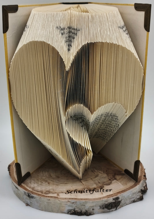 Gefaltetes Buch mit gebrochenem Herz-Motiv aus Buchfaltkunst auf Birkenscheibe, Frontansicht