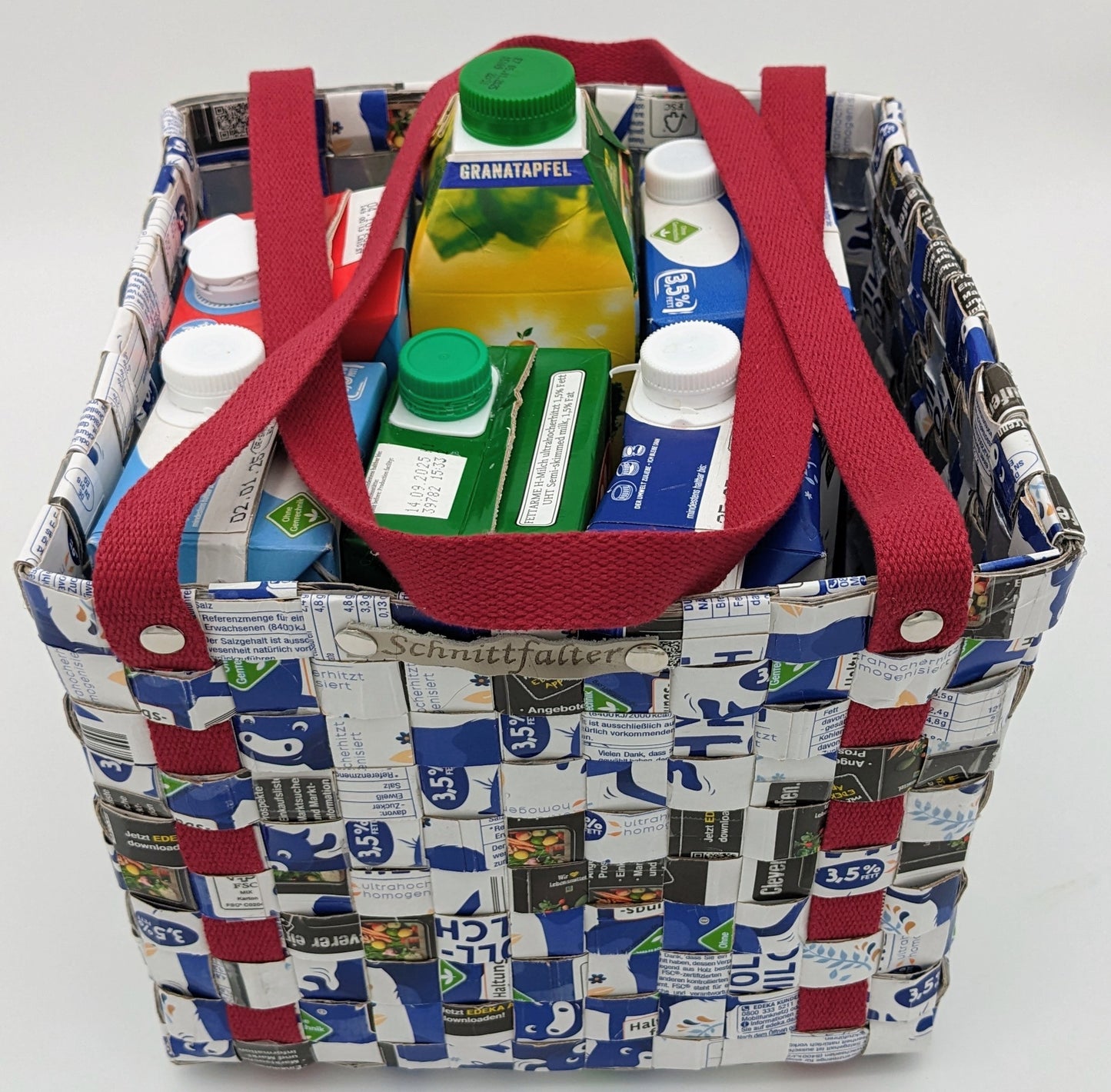 Upcycling-Tasche aus Getränkekartons in Blau-Weiß mit bordeauxfarbenem Griff – Frontansicht mit sichtbaren Tetrapacks
