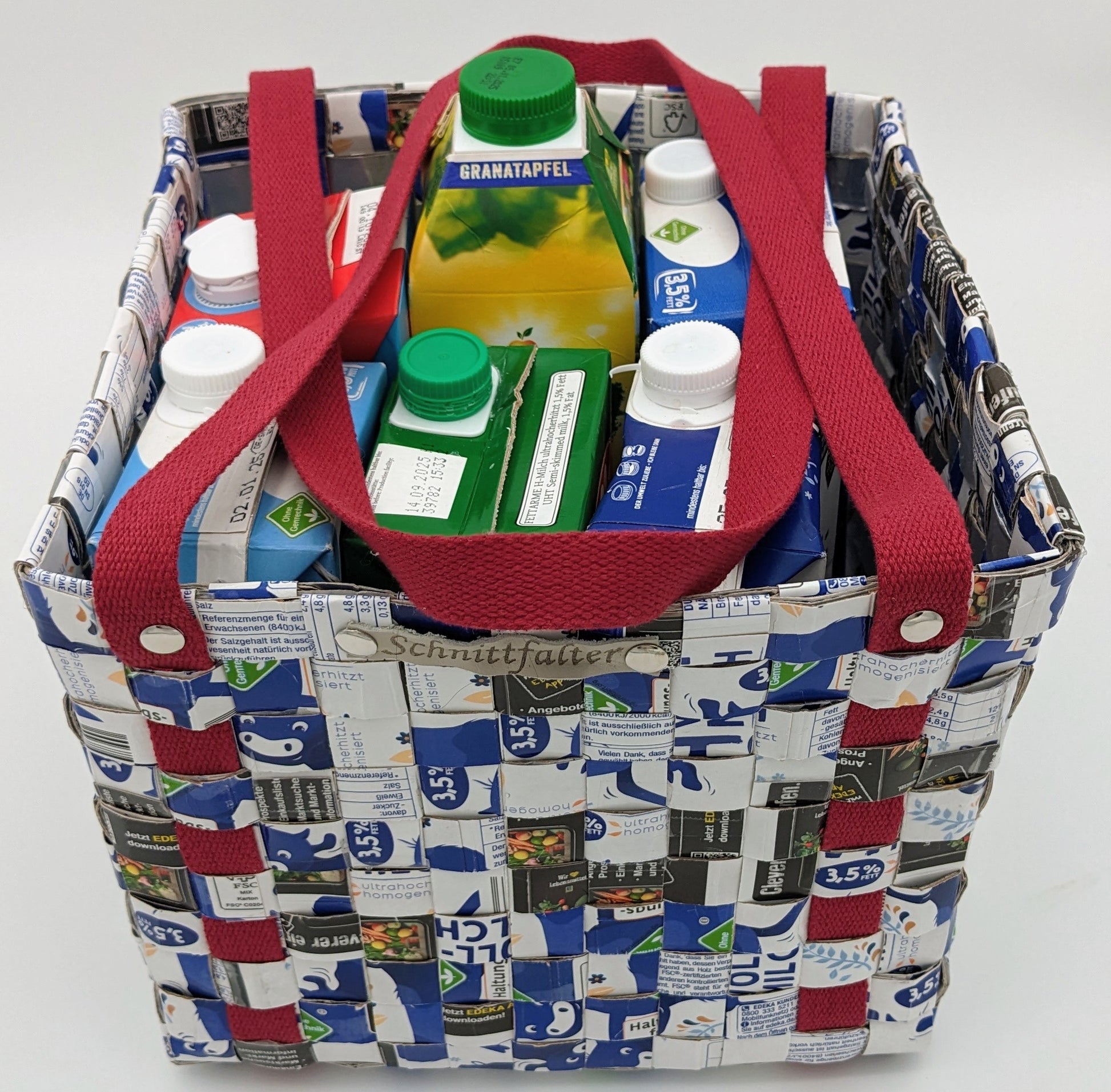 Upcycling-Tasche aus Getränkekartons in Blau-Weiß mit bordeauxfarbenem Griff – Frontansicht mit sichtbaren Tetrapacks
