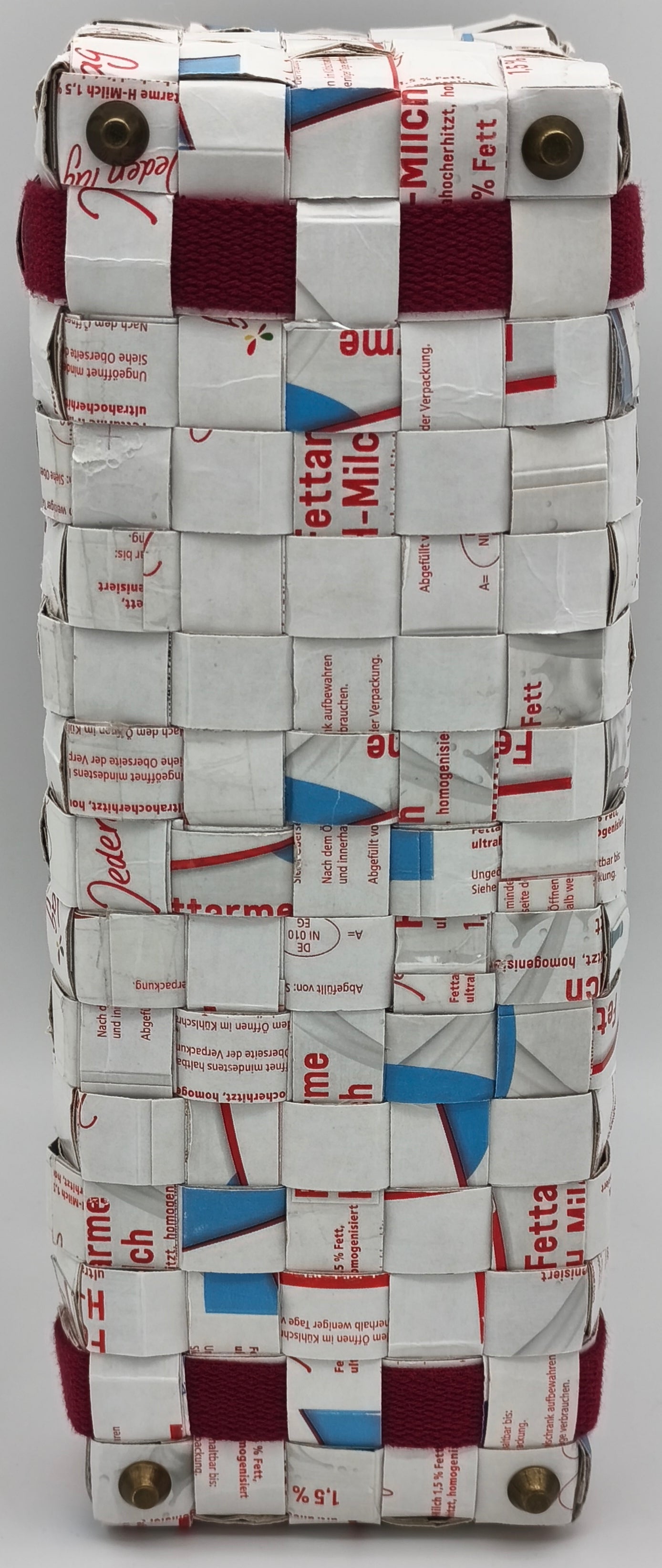Bodenansicht:der Upcycling-Einkaufstasche aus Milch-Tetrapack mit bordeauxrotem Gurtband und Metallnieten für besseren trockenen Stand