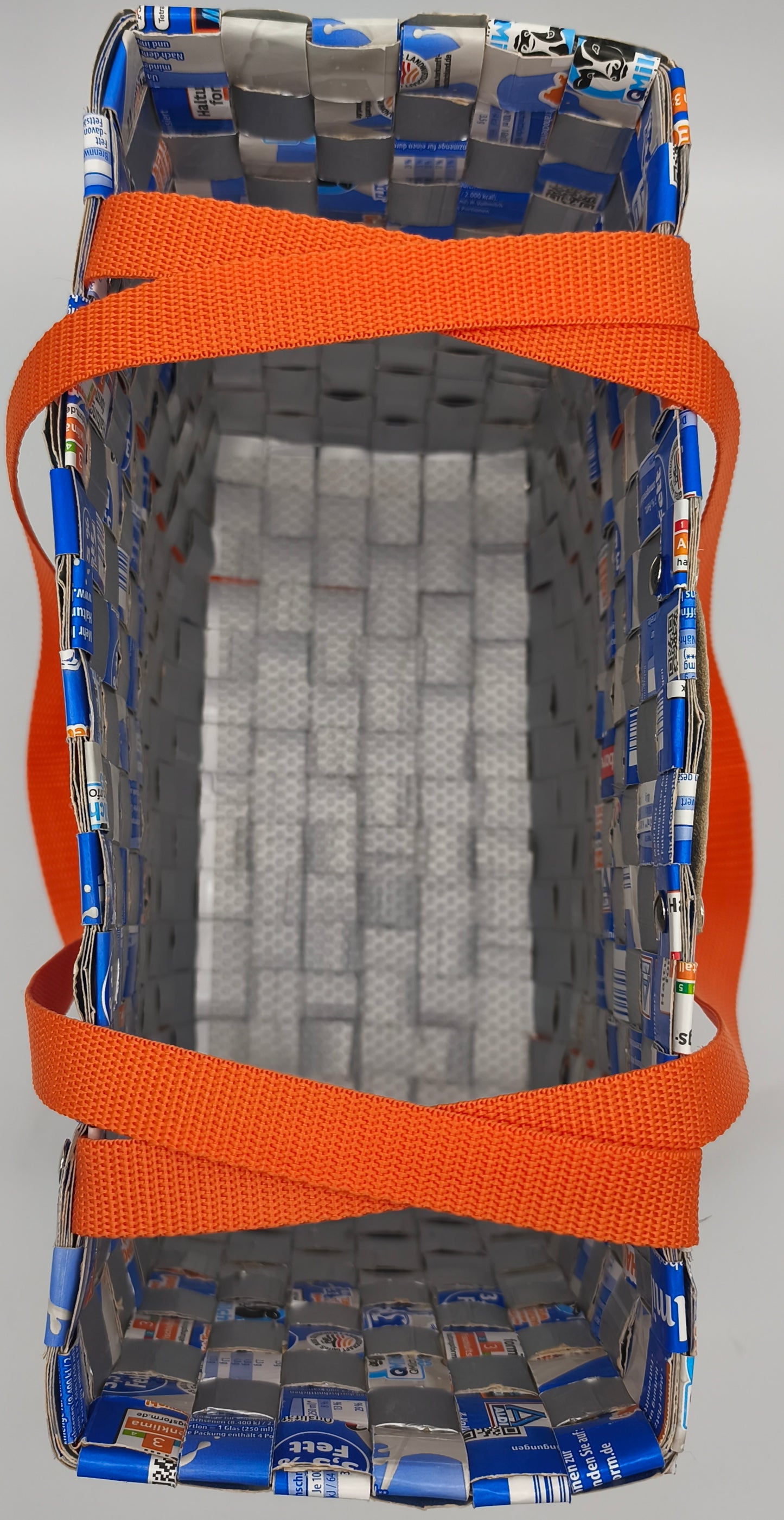 Seitenansicht der Upcycling-Einkaufstasche Blau-Orange aus Milch-Tetrapack mit umlaufendem orangem Gurtband
