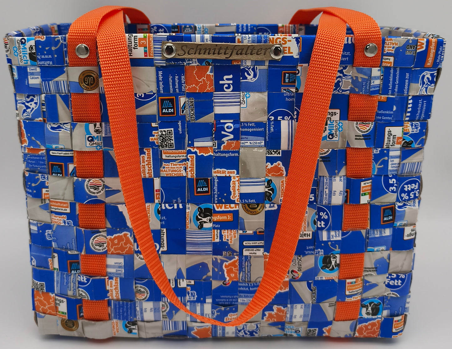  Upcycling Einkaufstasche Blau-Orange aus Milch-Tetrapack, Frontansicht mit umlaufendem orangem Gurtband und Schnittfalter-Label
