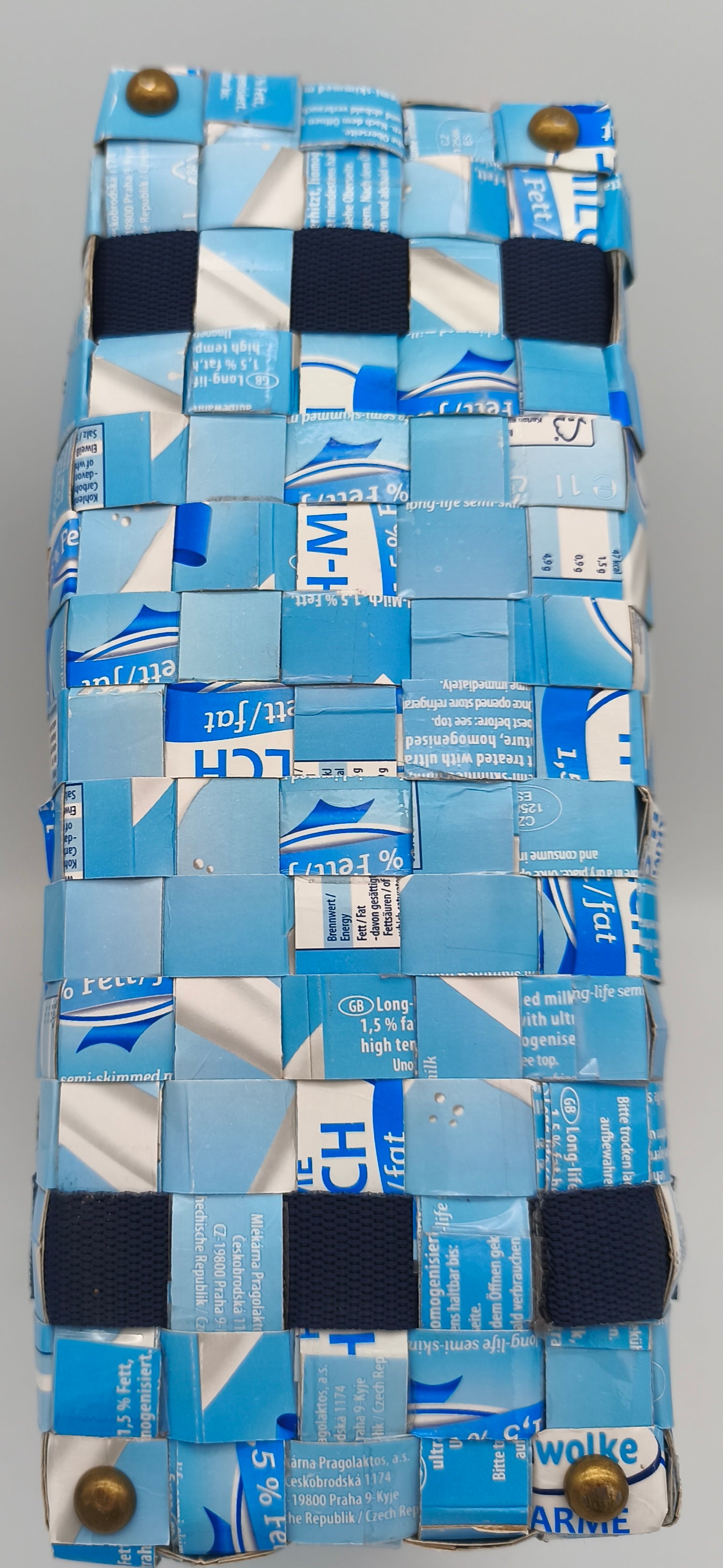Bodenansicht der Upcycling-Einkaufstasche Hellblau-Weiß aus Milch-Tetrapack mit goldenen Taschenfüßen und blauem Gurtband
