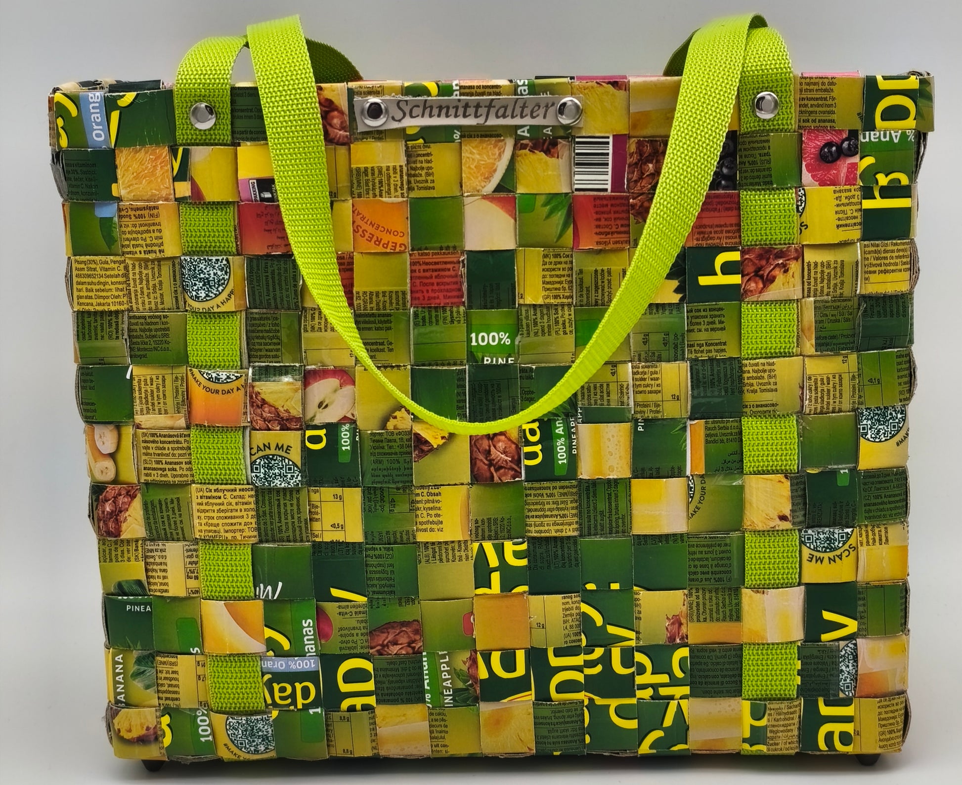 Upcycling Einkaufstasche Grün-Gelb aus Safttüten, Frontansicht mit neongrünem Gurtband und Schnittfalter-Label
